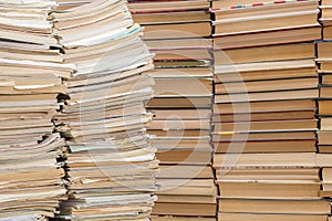 A stack of old school notebooks and a stack of textbooks or books