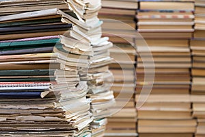 A stack of old school notebooks and a stack of textbooks or books