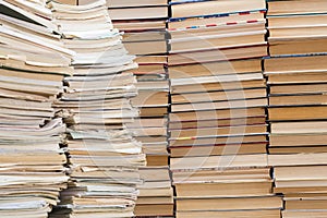 A stack of old school notebooks and a stack of textbooks or books