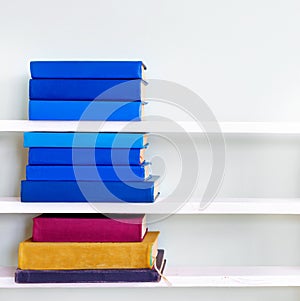 Stack of old vintage blue books on wooden shelf in university library