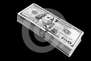 Stack of one hundred dollar bills isolated on black background. Stack of cash money in hundred dollar banknotes. Heap of hundred d