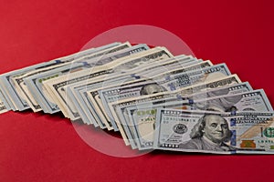 Stack of one hundred dollar bills new and old design on red background.