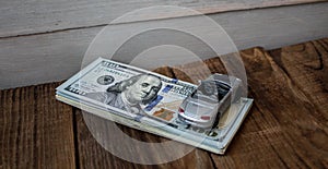 A stack of one hundred dollar bils on wooden background