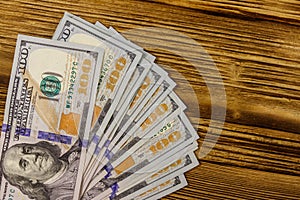 Stack of one hundred dollars bills on wooden desk