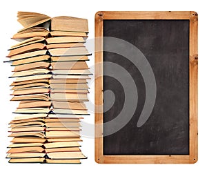 Stack of open books with school blackboard