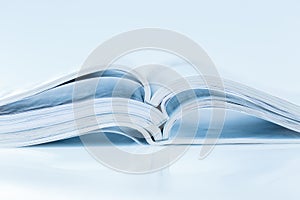Stack of open magazines in blue tone