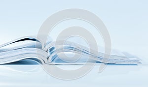 Stack of open magazines in blue tone