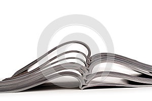 A stack of open magazines on white