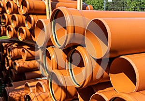 Stack of orange pipes at a construction site