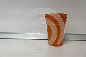 Stack of Orange Plastic Cups on White Surface