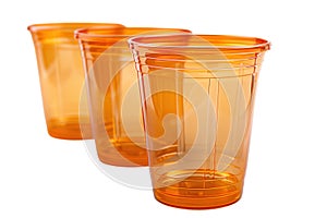 Stack of orange plastic disposable cups on white background.