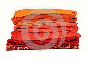 Stack orange winter clothes isolated on white background.
