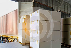 Stack of Package Boxes Load into Cargo Container. Truck Parked Loading at Dock Warehouse. Delivery Service. Shipping Warehouse.