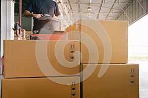 Stack of Package Boxes at the Warehouse. Woker Driving Forklift Pallet Jack. Shipment Boxes.