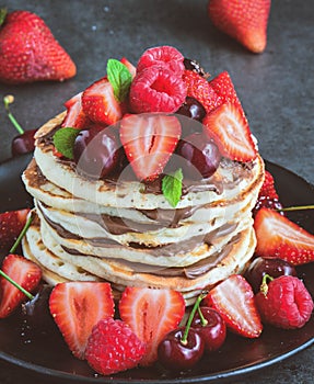 Stack of pancake with nutella and fresh berries