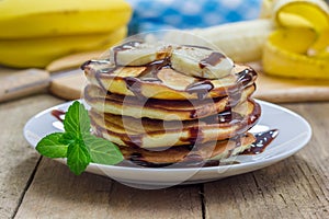Stack of pancakes with banana and chocolate syrup
