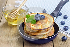 Stack of pancakes with blueberry and honey