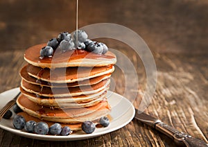 Stack of pancakes with blueberry and maple syrup