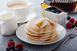 Stack of pancakes with butter and syrup pouring over