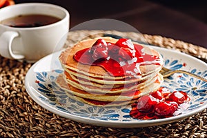 Stack of pancakes with cornelian cherry jam on plate