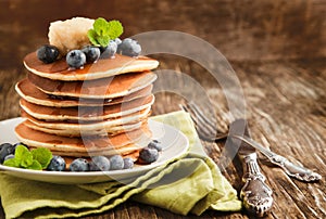 Stack of pancakes with fresh blueberry,maple butter and syrup on