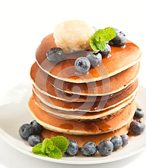 Stack of pancakes with fresh blueberry, maple butter and syrup