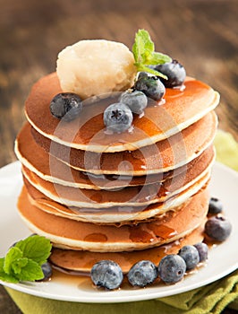 Stack of pancakes with fresh blueberry,maple butter and syrup