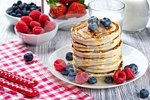 Stack of pancakes with fresh blueberry, raspberry and honey, milk and fresh berries, healthy breakfast concept