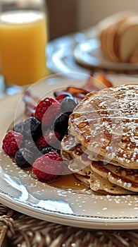 A stack of pancakes generously topped with fresh berries and drizzled with syrup, creating a delicious and indulgent