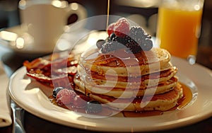 A stack of pancakes generously topped with fresh berries and drizzled with syrup, creating a delicious and indulgent