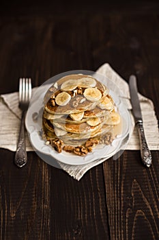 Stack of pancakes with honey,banana and walnuts