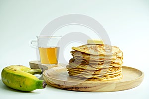 Stack of pancakes with honey syrup,butter and banana