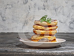 A stack of pancakes with sugar powder and mint