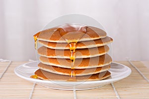 Stack of pancakes with syrup or honey