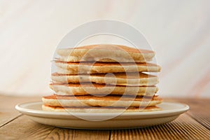 Stack of pancakes on wooden background. Homemade american pancakes, isolated