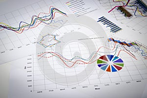 Stack of paper documents with financial reports and statistic in