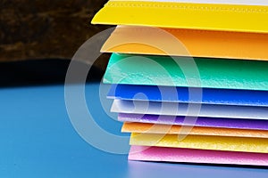 A row of multi-colored plastic folders for paper on a blue background