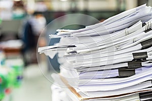 The stack of paper lay on a messy office table.