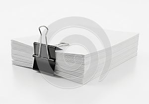 Stack of papers with a black binder clip