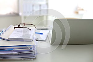 Stack of papers and glasses lying on table