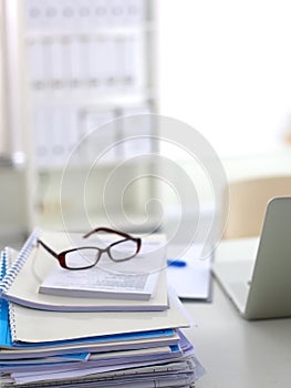 Stack of papers and glasses lying on table