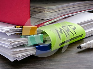 Stack of papers and label MRP Material requirements planning. photo
