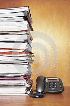 Stack of paperwork and telephone on desk