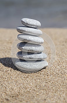 Stack of pebble stones on balance on sand