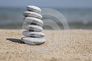 Stack of pebble stones on balance on sand