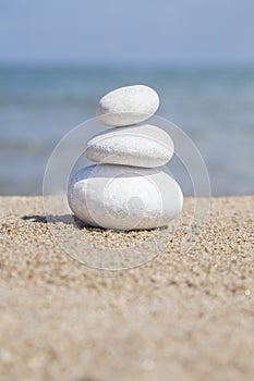 Stack of pebble stones on balance on sandy beach