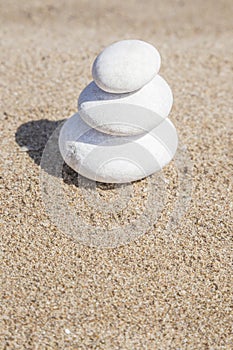 Stack of pebble stones on balance on a sandy beach with copy space