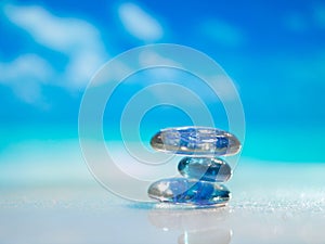 Stack of pebble stones and Plumeria at the beach on a wooden surface. Concept Zen, Spa, Summer, Beach, Sea, Relax