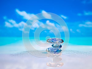 Stack of pebble stones and Plumeria at the beach on a wooden surface. Concept Zen, Spa, Summer, Beach, Sea, Relax