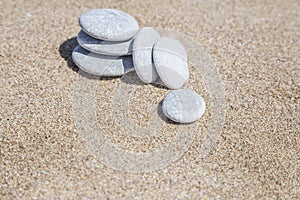 Stack of pebble stones unbalanced on a sandy beach